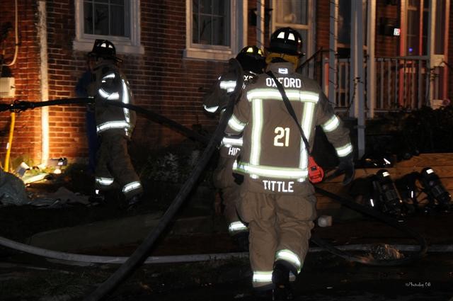 Firefighters Bill Hirthler and Tery Tittle moving a handline on the Fourth Street fire.